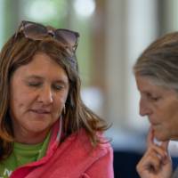 two woman consulting over a laptop